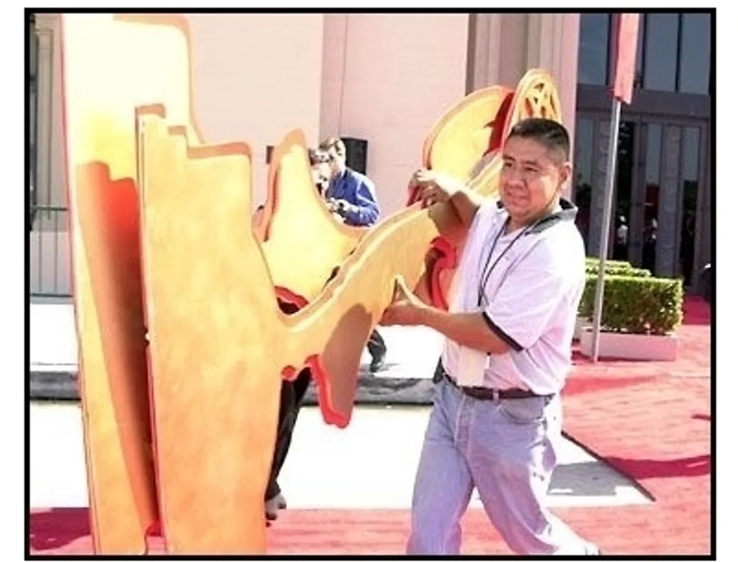 Emmy 2001 Cancellation: Rigo Guardado removes two of the Emmy decorations from the red carpet arrivals area